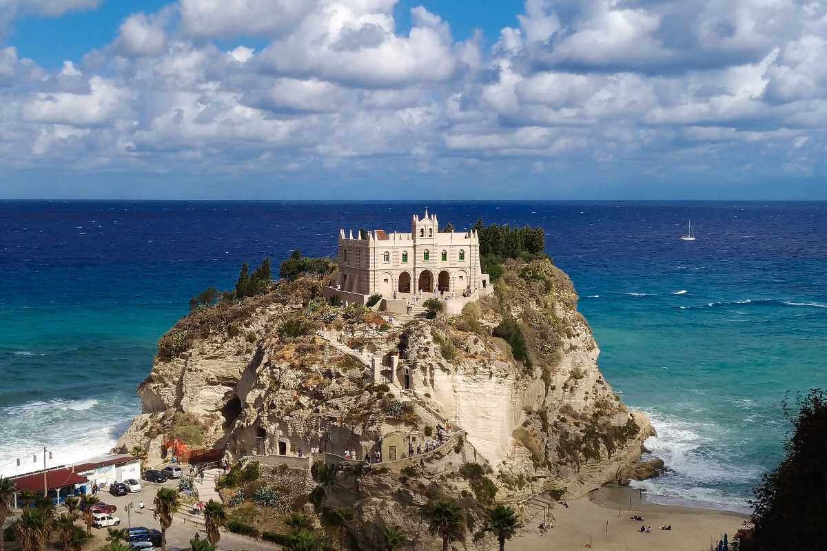 Panoramica della rupe di Tropea al tramonto, con il Santuario di Santa Maria dell’Isola in primo piano e il mare sullo sfondo