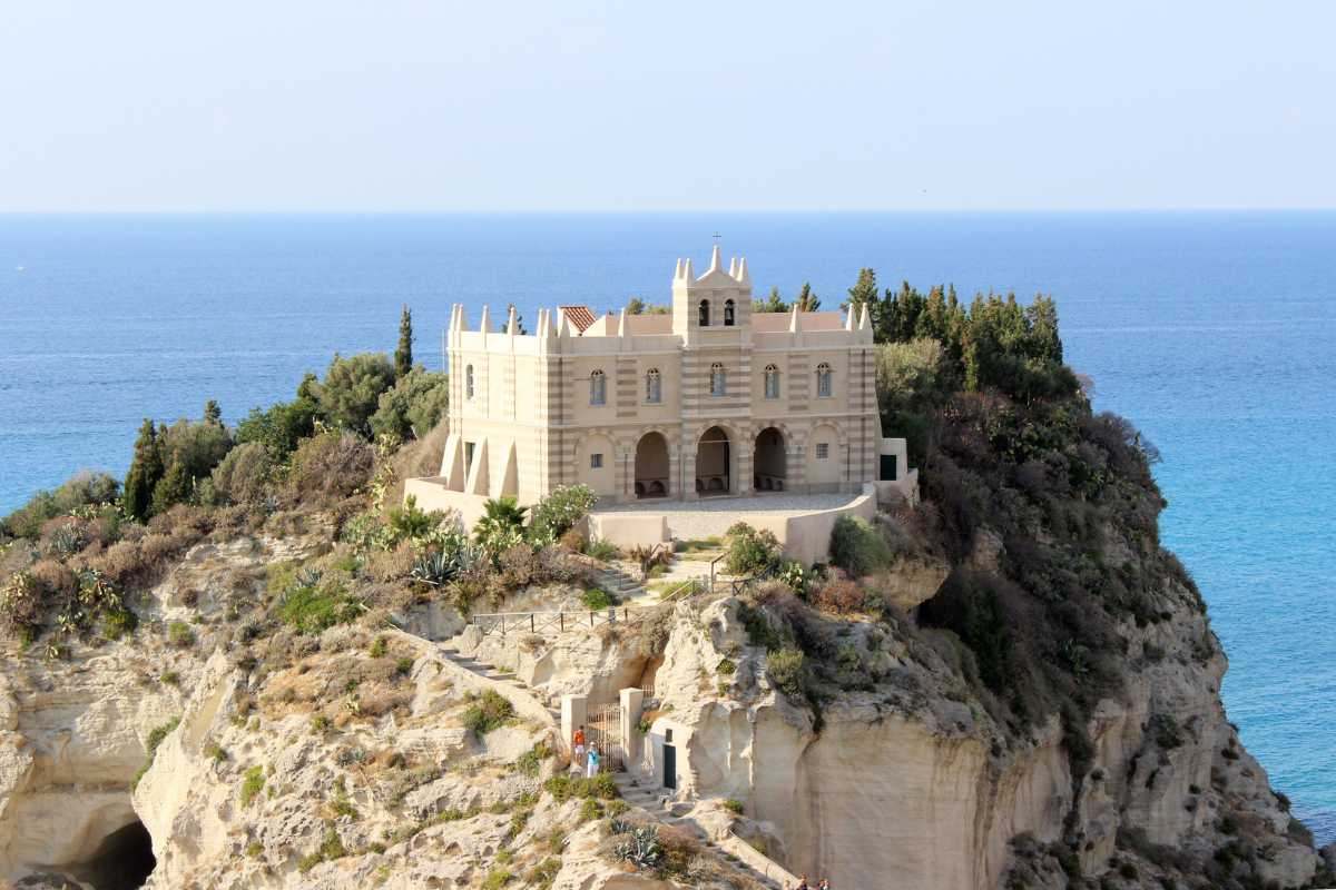 Famiglia che si rilassa nel Giardino del Santuario di Santa Maria dell’Isola, con vista sul mare e sul borgo di Tropea